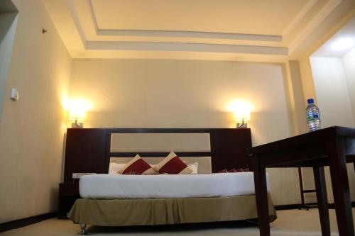 a bedroom with a bed with red pillows at Harmony Hotel in Addis Ababa