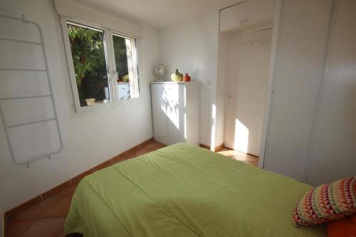 une chambre avec un lit vert et une fenêtre dans l'établissement 50m de la plage vue mer Très belle maison 3 chambres 5 couchages grand jardin parking voitures LXMURIER, à Portiragnes