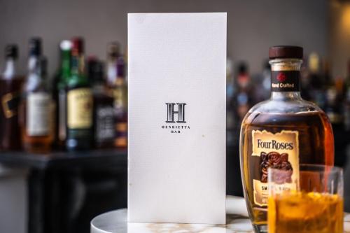 a bottle of bourbon sitting next to a glass at The Roseate Villa Bath in Bath