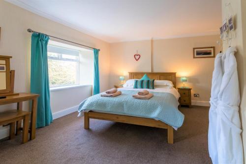 ein Schlafzimmer mit einem Bett mit zwei Handtüchern darauf in der Unterkunft Host & Stay - Daisy Cottage in Bamburgh