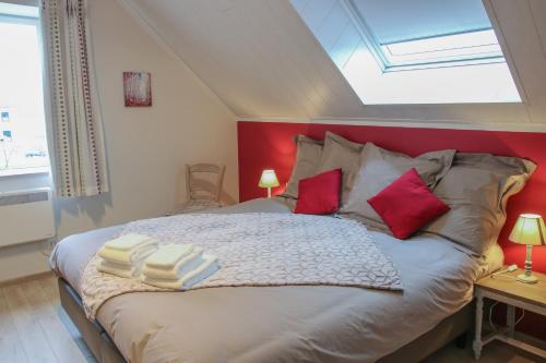 een slaapkamer met een groot bed met een rood hoofdeinde bij La petite maison dans la cour in Stave