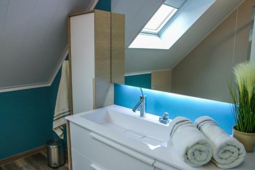een badkamer met een wastafel en een spiegel bij La petite maison dans la cour in Stave