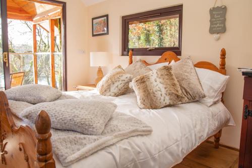 a bedroom with a bed with white sheets and pillows at Finest Retreats - The Tree House - Eco-Friendly, Back to Nature Experience in Germansweek