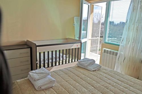 a bedroom with a bed with towels on top of it at Вила в с. Габарево, Долината на Розите. in Gabarevo