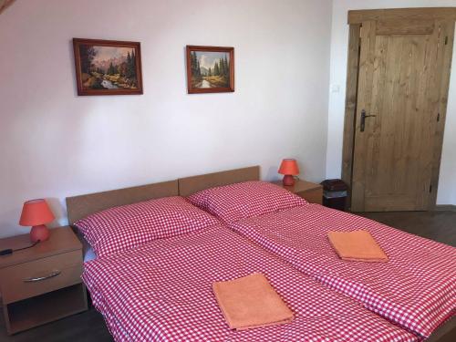sypialnia z czerwonym łóżkiem z 2 poduszkami w obiekcie Penzión Bachleda w Zdziarze