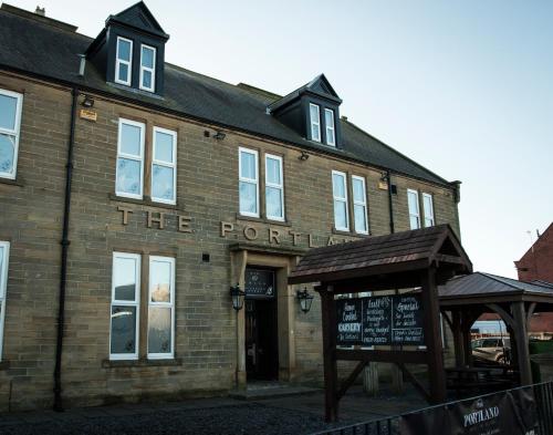 a brick building with a sign in front of it at The Portland in Ashington