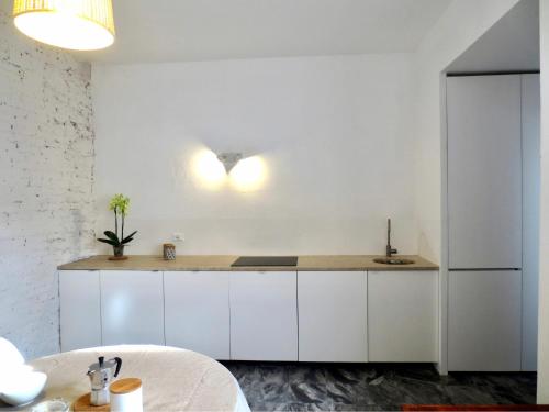 a kitchen with white cabinets and a sink and a table at Villa Anna in Torre del Lago Puccini