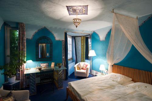 Schlafzimmer mit einem Bett, einem Schreibtisch und einem Spiegel in der Unterkunft Hotel Goldflair am Rathaus in Korbach