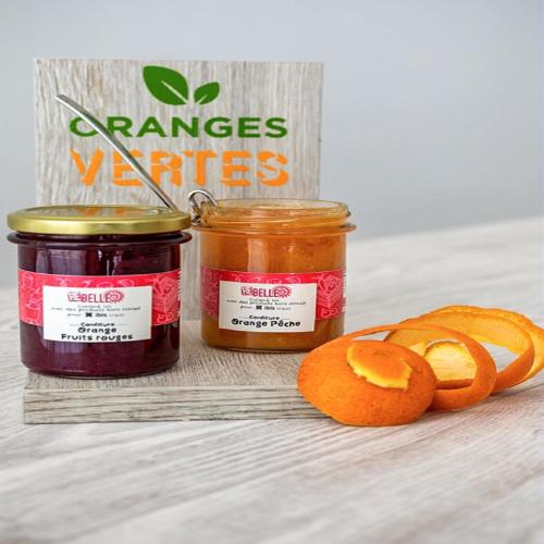 two jars of preserves next to a sliced orange at ibis Styles Le Puy en Velay in Le Puy en Velay