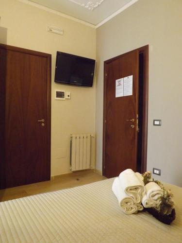 a hotel room with a bed and a tv on the wall at La Maison Des Rêves in Syracuse