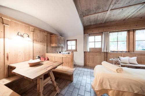 a room with two beds and a wooden table at Hotel Alpenhof in Ultimo