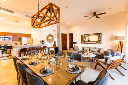 a dining room and living room with a table and chairs at Petit Luxe Las Gavias Penthouse in Mazatlán