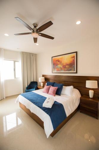 a bedroom with a large bed with a ceiling fan at Petit Luxe Las Gavias Penthouse in Mazatlán