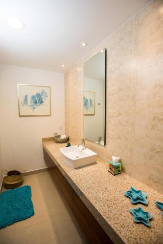 a bathroom with a sink and a mirror at Petit Luxe Las Gavias Penthouse in Mazatlán