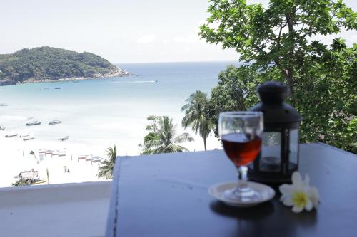 a glass of wine on a table with a view of the beach at Aman Dan Laut in Perhentian Island
