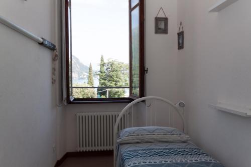 Una pequeña habitación con una cama y una ventana. en Breva - Menaggio by LoveComo, en Menaggio