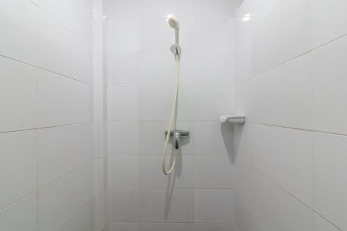 prysznic w białej, kafelkowej łazience w obiekcie Chaiyo Resort w Phuket