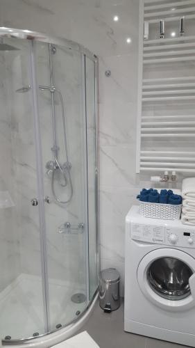 a shower and a washing machine in a bathroom at Baltica Towers AP1108 apartament studio in Gdańsk