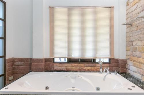 una bañera en un baño con ventana en Chaiyo Resort, en Phuket