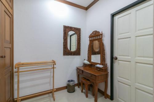 Chaiyo Resort في فوكيت تاون: حمام مزود بخزانة خشبية ومرآة