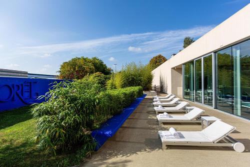 a row of white lounge chairs on the side of a building at Là Di Moret in Udine