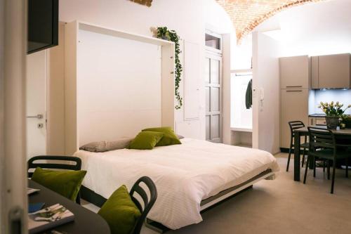 1 dormitorio con 1 cama, mesa y sillas en Mameli Premium, en Casale Monferrato