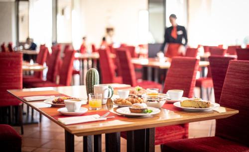 a table with plates of food on it in a restaurant at Acaya Golf Resort & Spa in Acaya