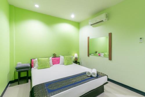 une chambre avec un lit avec un miroir et une chaise dans l'établissement Chaiyo Resort, à Phuket
