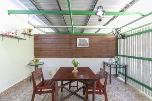 Chaiyo Resort في فوكيت تاون: غرفة طعام بها طاولة وكراسي خشبية