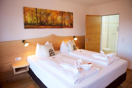 a bedroom with two beds with white pillows at Hotel Alpenglühn in Füssen