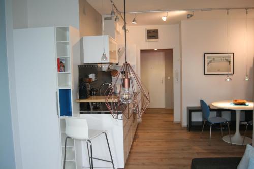 eine Küche mit weißen Schränken, einem Tisch und Stühlen in der Unterkunft Centrum 2 Apartmanok in Hévíz