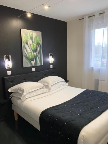 een slaapkamer met een bed met een schilderij aan de muur bij Hotel Restaurant Baryton in Saint-Marcel