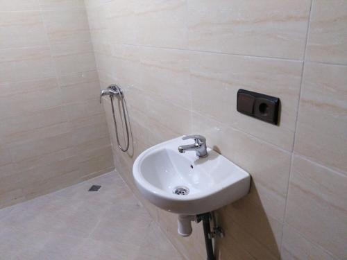 uma casa de banho com um lavatório e um dispensador de sabão na parede em Dar Khalifa Airport em Nouaseur
