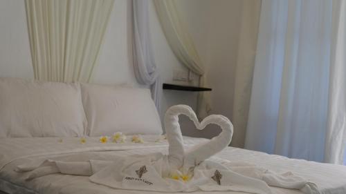 a bed with swans making a heart on it at Aman Dan Laut in Perhentian Island