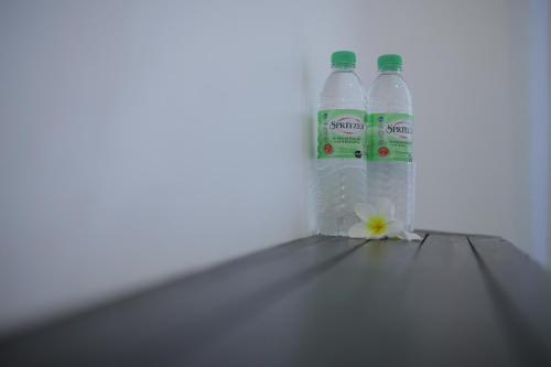 two bottles of water and a flower on a shelf at Aman Dan Laut in Perhentian Island