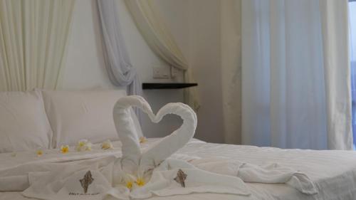 two swans making a heart on a bed at Aman Dan Laut in Perhentian Island