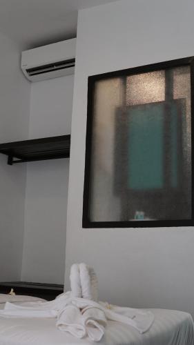 a bedroom with a window and a bed with white sheets at Aman Dan Laut in Perhentian Island