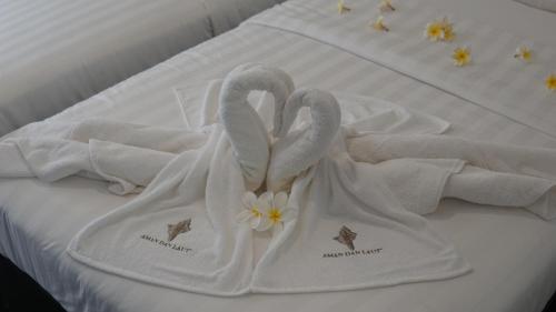 two swans towels on top of a bed at Aman Dan Laut in Perhentian Island