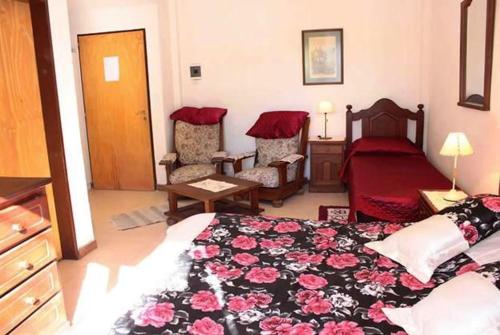 a bedroom with a bed and two chairs in it at La Casona de Susana in Colón