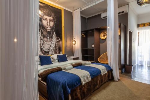 - une chambre avec un grand lit orné d'une peinture murale dans l'établissement Ngoma Zanga Lodge, à Livingstone