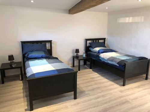 2 Betten in einem Zimmer mit 2 Tischen in der Unterkunft Gemütliche Ferienwohnung - Monteurzimmer in der Wittstocker Altstadt in Wittstock