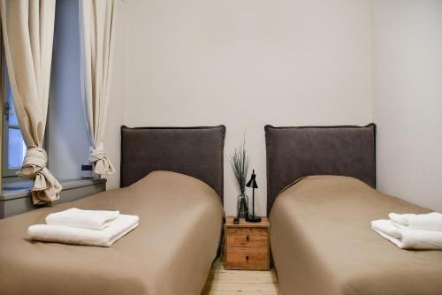 two beds sitting next to each other in a room at Erst Guest House in Athens