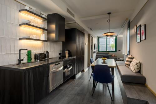 a kitchen and living room with a table and a couch at Be Mate Paseo de Gracia in Barcelona