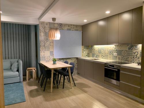 a kitchen with a table and a dining room at Casa do Recife, Natureza e Conforto in Viana do Castelo