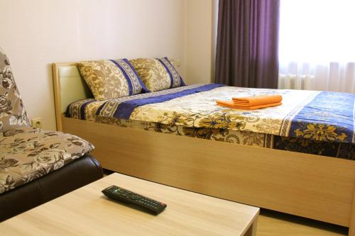 スィクティフカルにあるNord City Sysolskoye Shosse 19のベッドルーム1室(ベッド1台、テーブルのリモコン付)