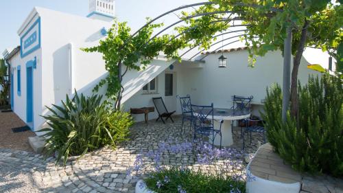 a courtyard in a house with a table and chairs at Casa Flor de Sal in Moncarapacho