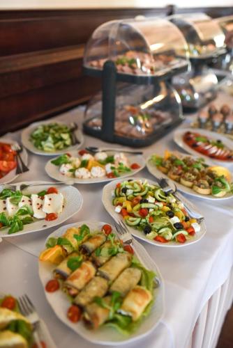 プウォツクにあるHotel Czardasz Spa & Wellnessのテーブルの上に料理が並んだビュッフェ