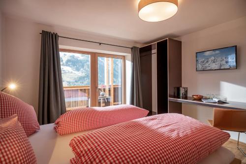 een hotelkamer met 2 bedden en een raam bij Apartments Zauberberg in Hainzenberg