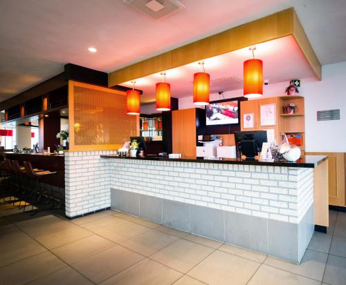 a bar in a restaurant with orange lights at Bastion Hotel Dordrecht Papendrecht in Dordrecht