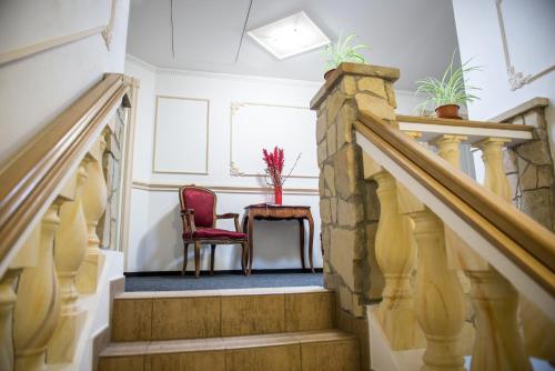 a staircase with a red chair and a table at Penzion Monika in Hrušovany nad Jevišovkou